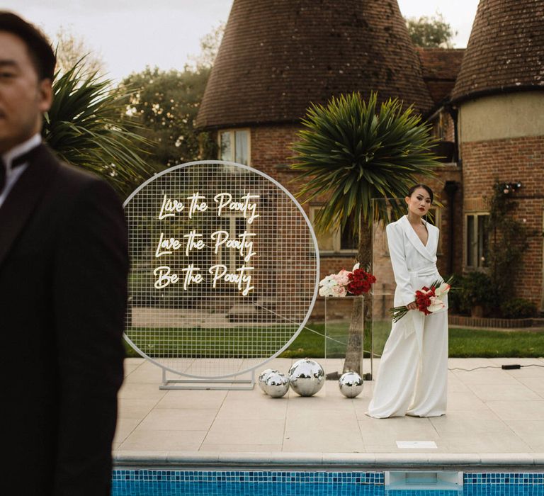 Neon wedding sign at outdoor pool reception party