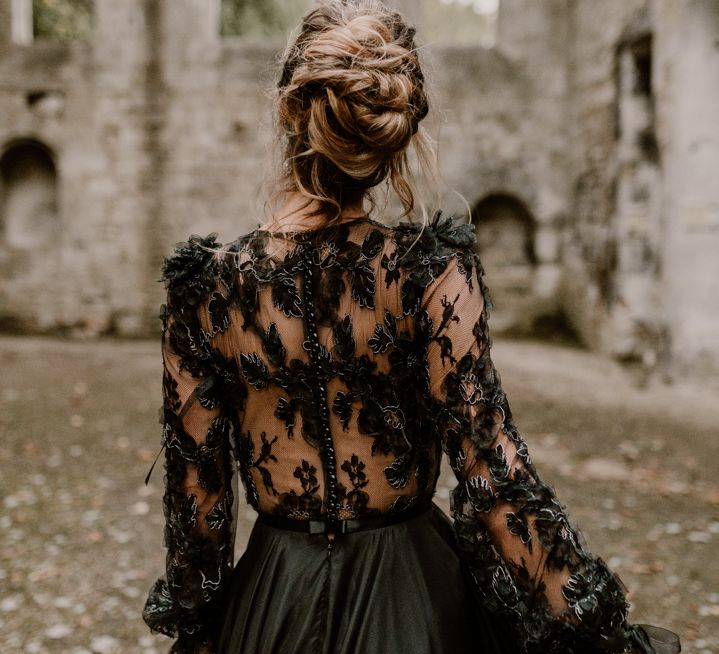 Gothic bride with a pinned bridal up do and sheer lace black wedding dress