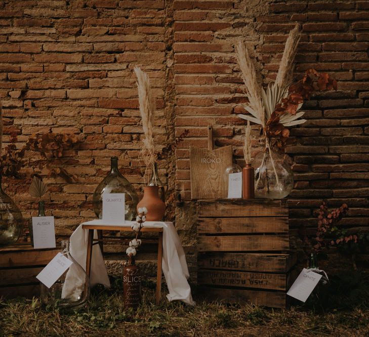 Rustic table plan with wooden crates, cutting boards and apothecary jars 