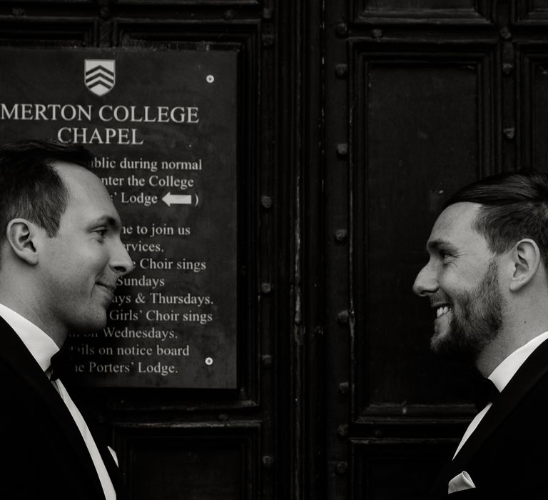 Grooms look at one another lovingly in black & white image