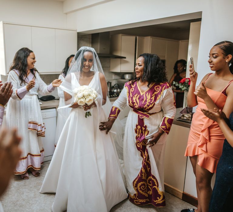 beautiful bride at Ethiopian wedding standing in the kitchen with her bridal party 