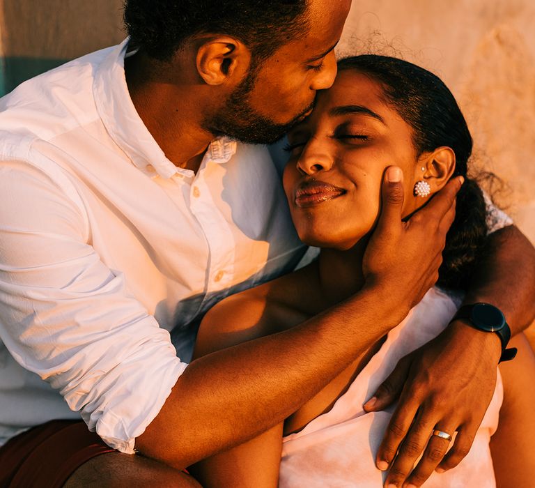 Groom puts hand to brides face on their honeymoon