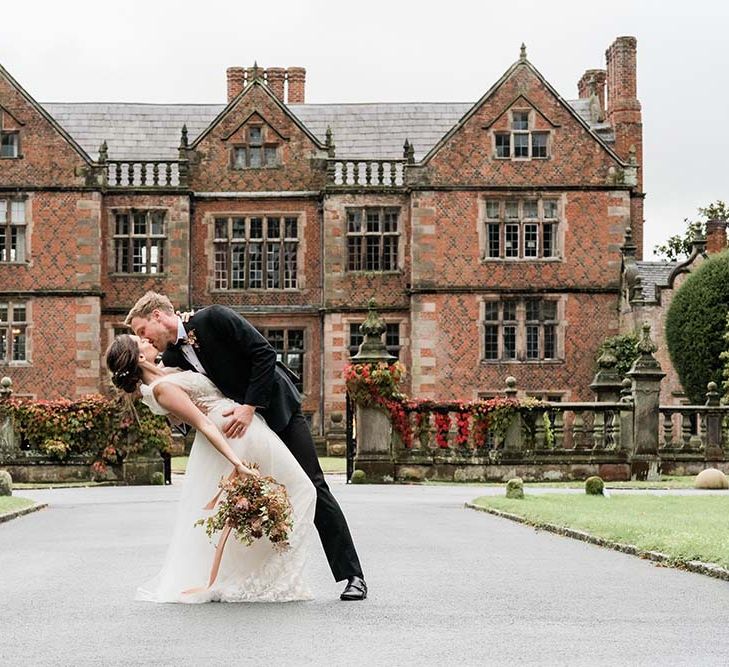 Bride and groom kissing outside Dorfold Hall country house wedding venue in Cheshire 