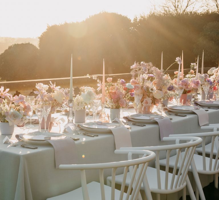 Golden hour sun shines over luxury wedding tablescape with white cloth