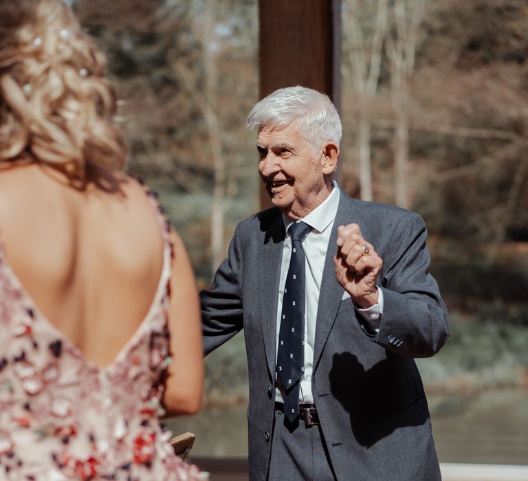 Wedding guest smiles and walks to bride 