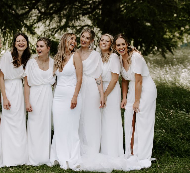 Bride stands with her bridesmaids who wear white dresses from ASOS