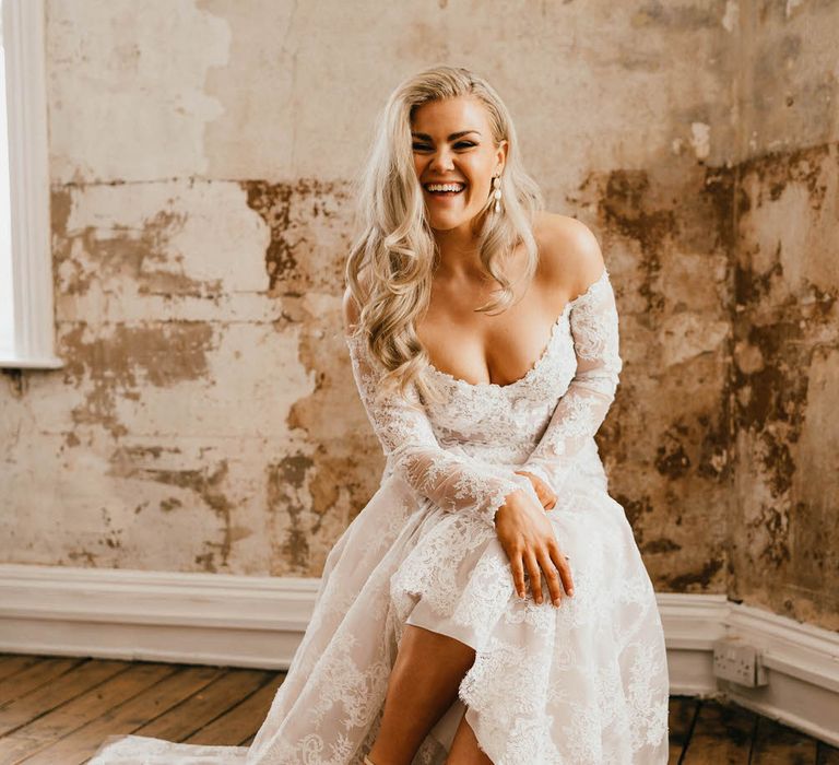 Bride laughing and showing off her fluffy white bridal heels by Diane Hassall