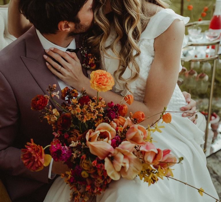 Bride and groom with orange and blush wedding flowers 