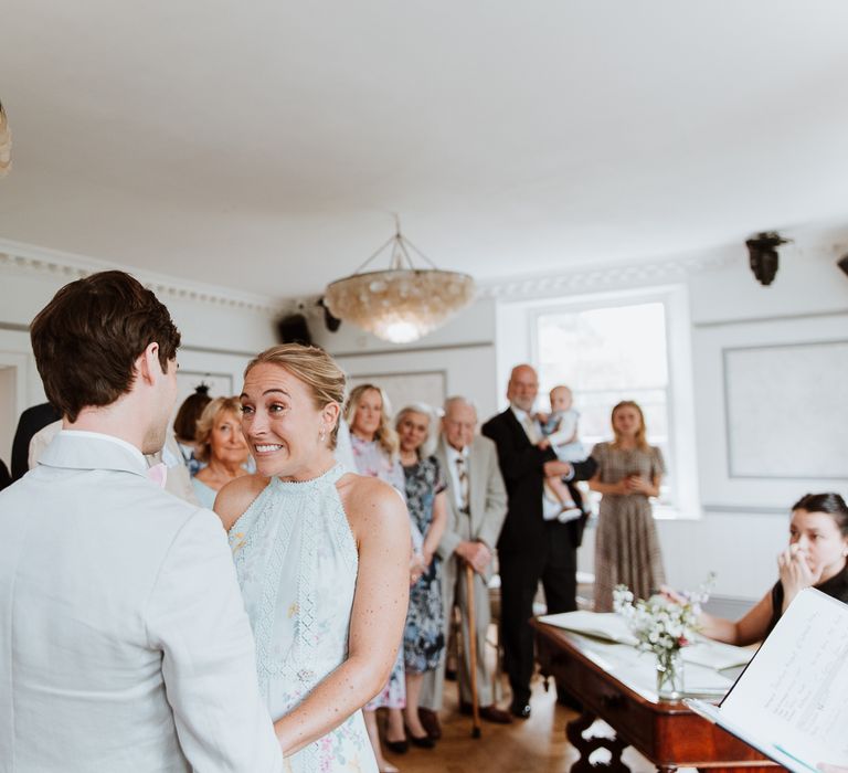 Bride & groom during wedding ceremony as bride wears pale blue wedding gown from Ted Baker