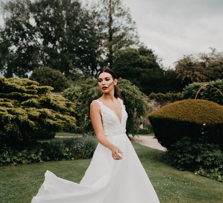 Bride in a Suzanne Neville wedding dress with appliqué fitted bodice and full skirt 