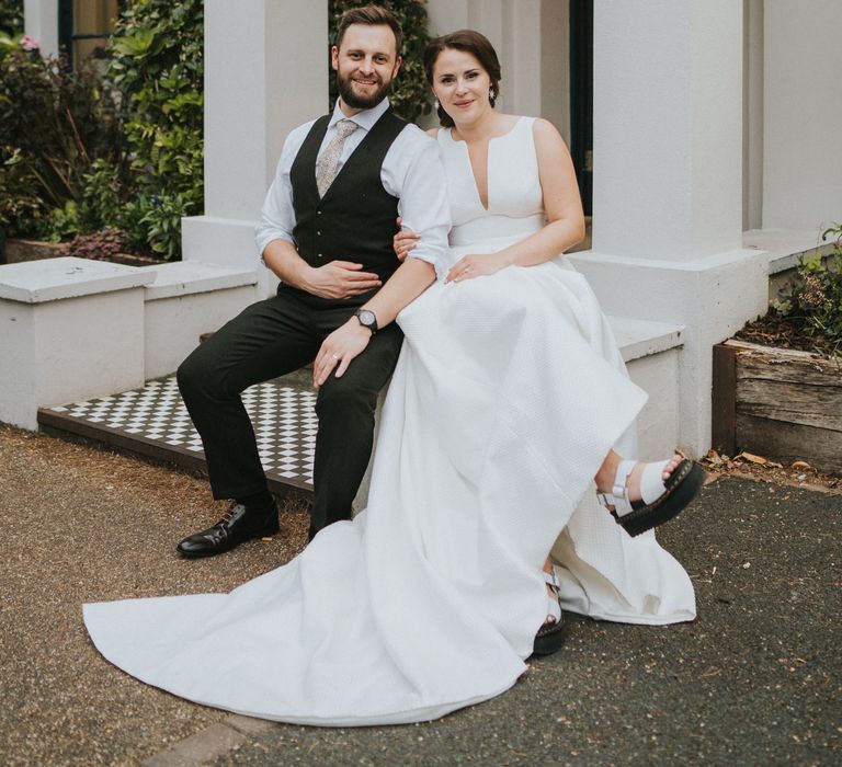 Bride and groom sit outside Georgian town house Norwich wedding venue