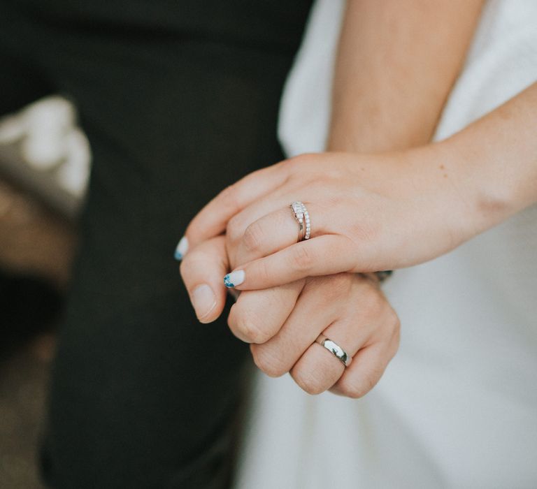 Bride with blue detail nail design holding hands with groom