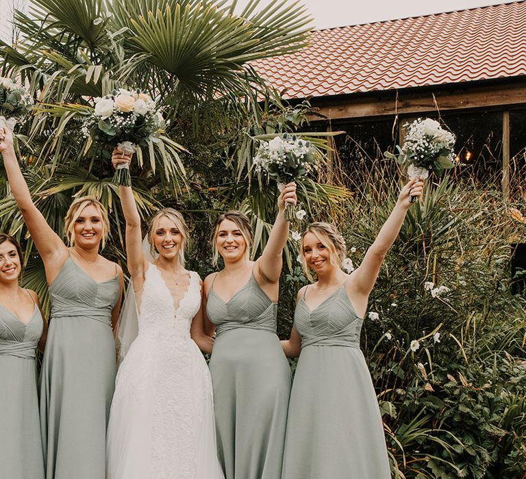 Sage green bridesmaid dresses with white flower bouquets