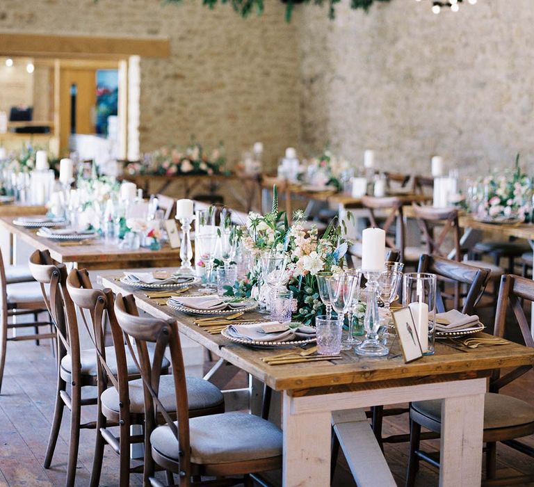 Rustic wedding reception complete with wooden tables and pastel florals