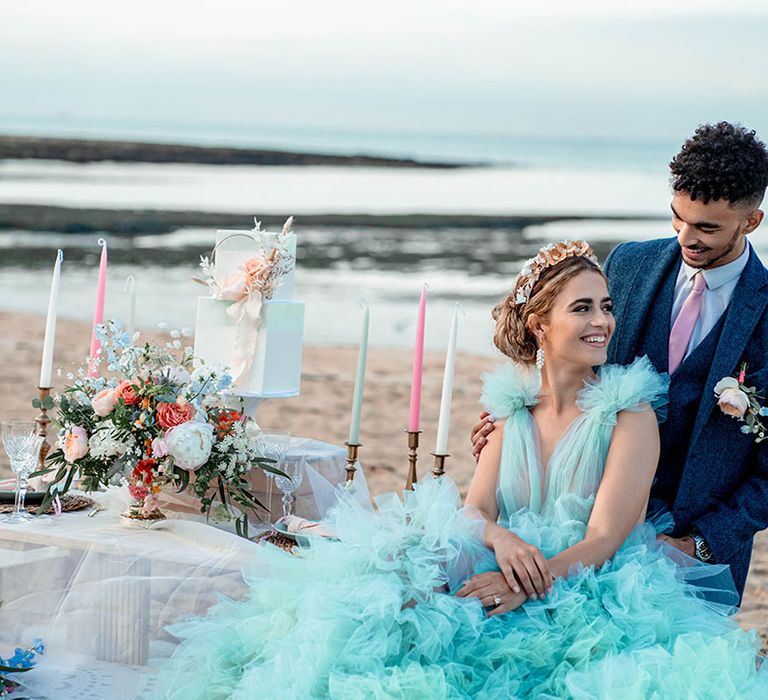 Pastel coloured beach wedding inspiration with bride in a mint green wedding dress and groom a blue wool suit 