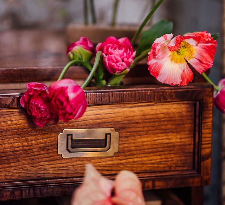 wooden draws filled with pink flower stems 