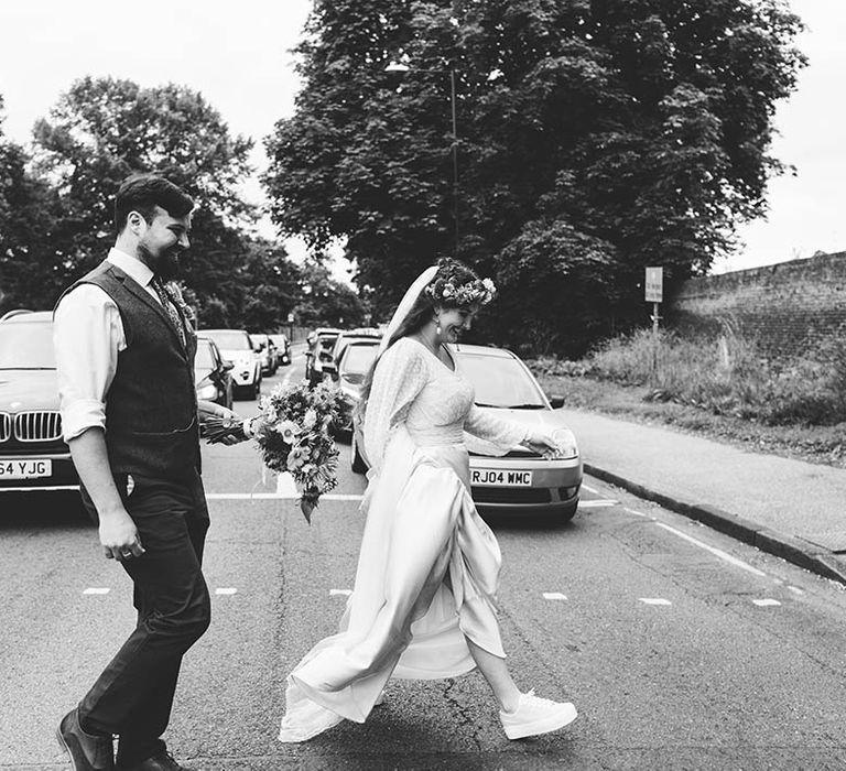 Black & white image of couple walking across the street with one another 