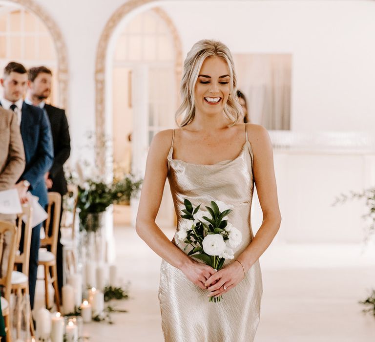 Bridal party walking down the aisle in satin slip champagne gold bridesmaid dresses 