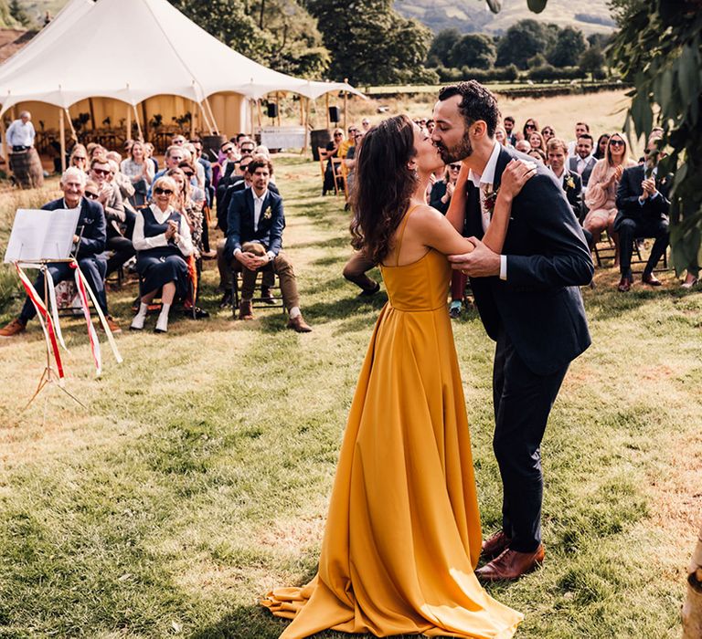 Bride & groom kiss outdoors