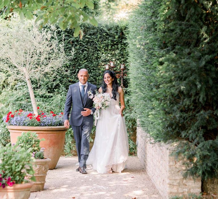 Bride walks to the aisle with her father on her wedding day