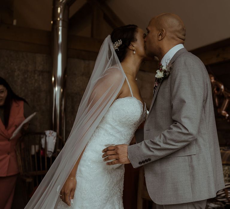 Bride wears floor length veil and embellished wedding gown