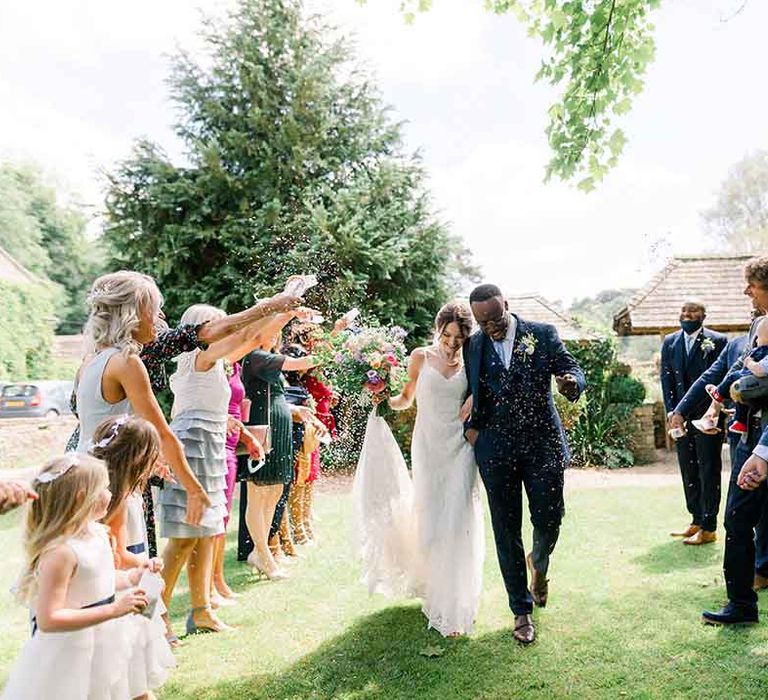 Bride & groom celebrate outdoors after wedding ceremony