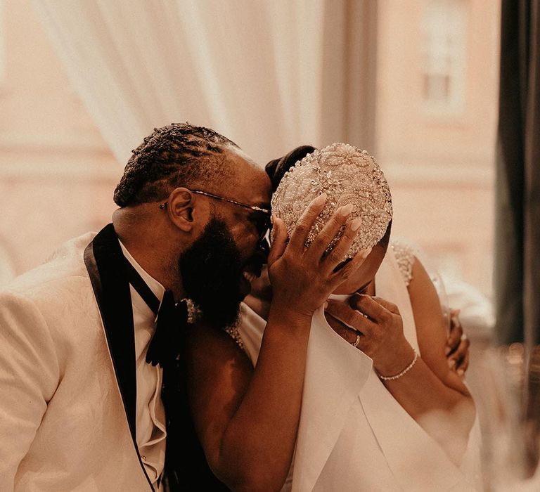 Intimate bride and groom photography during the vintage style wedding reception with bride in a jewel cap headdress 