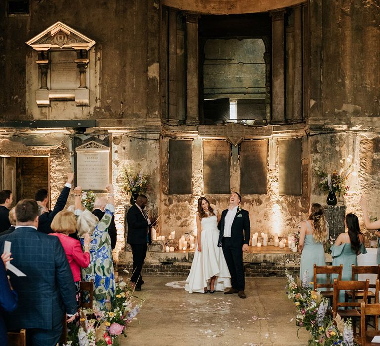 Everyone cheers as the bride and groom are announced as husband and wife in Asylum Chapel wedding venue