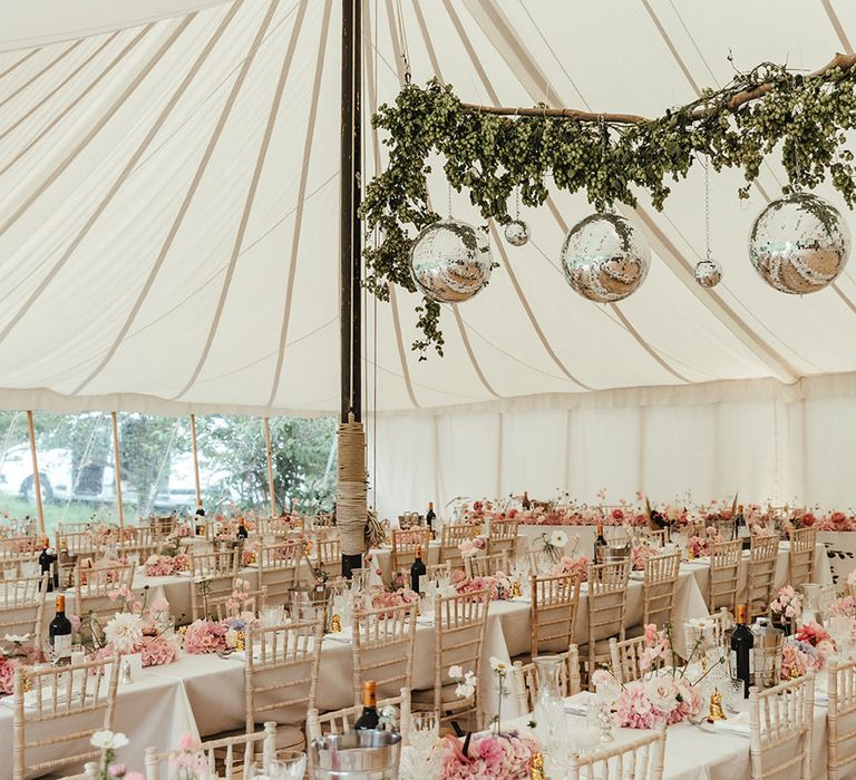 Marquee wedding with green foliage and small and large disco balls with pink themed table settings