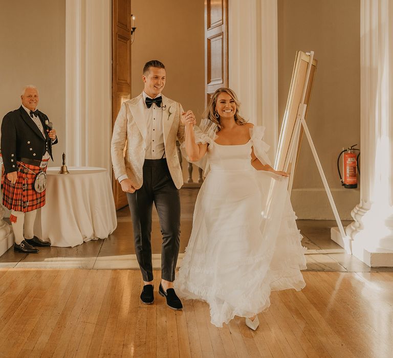 Bride and groom enter their wedding reception together