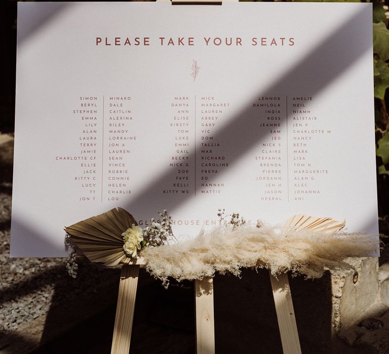 Pale pink table plan with dried grass decoration on an easel 