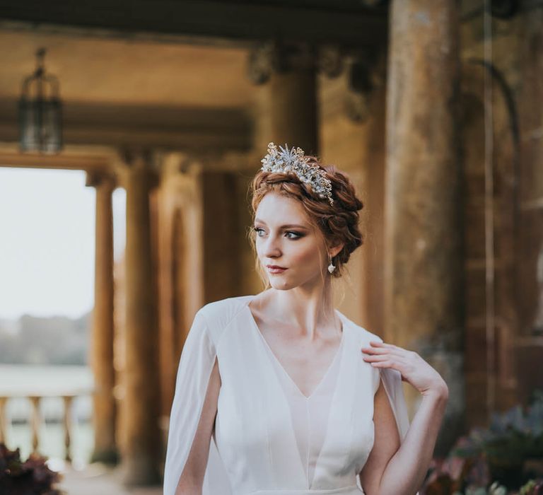 Bride with sparkly crown in a plain wedding dress and matching cape 