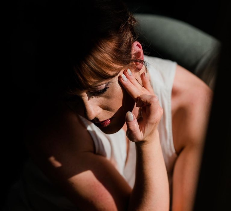 Bride does her makeup on the morning of her wedding day at Findon Place for classic wedding 