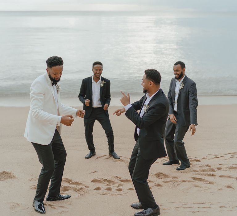 Groom dances with his groomsmen on the beach in Phuket after wedding ceremony 