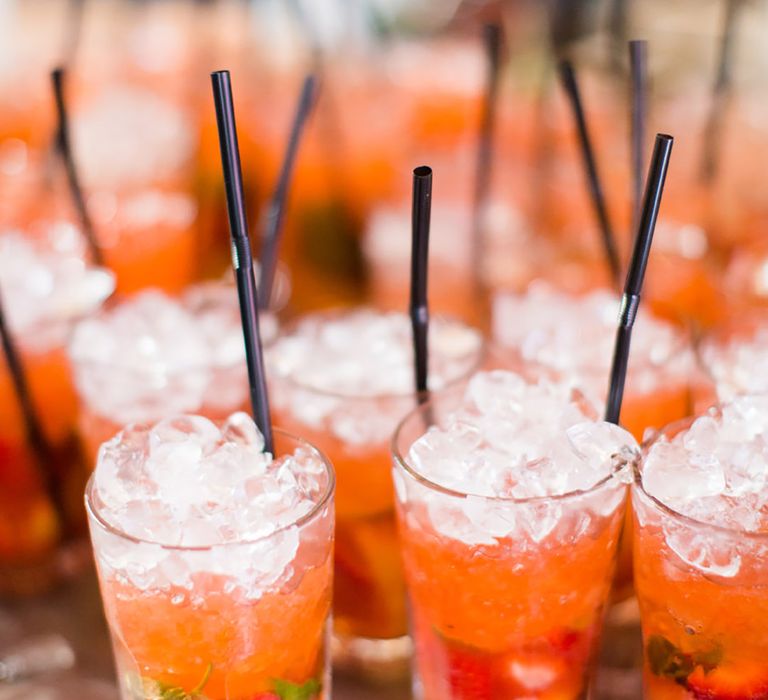 Orange coloured mocktail with mint and strawberries 