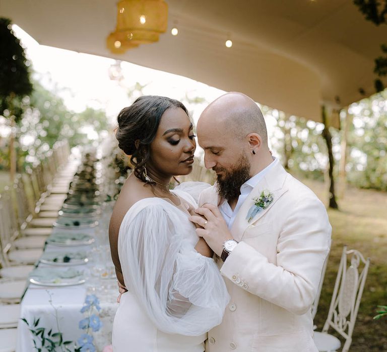 The happy couple dance in front of dinner setting at outdoor reception in Italy