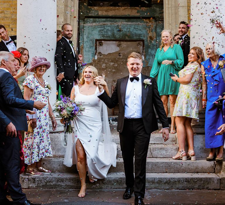 Bride and groom walk through confetti exit after wedding ceremony at The Asylum