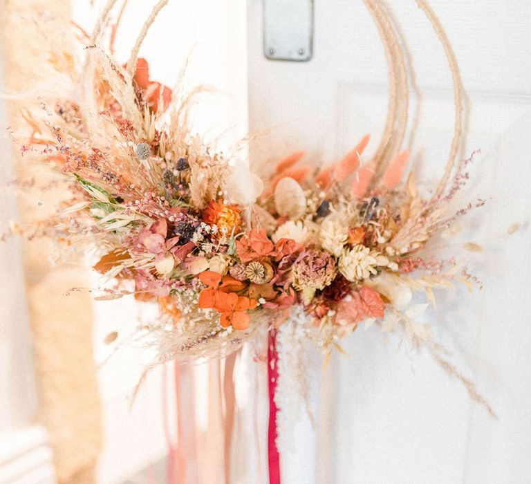 Autumnal coloured dried wedding flowers complete with rope and ribbon to the bottom