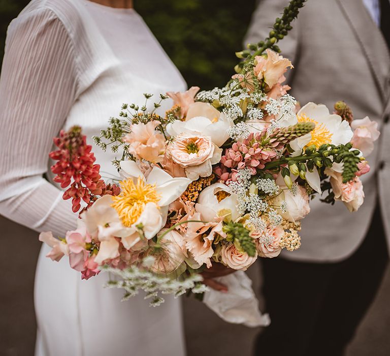 Tropical wedding bouquet with pink garden roses, red chrysanthemums, peonies, foliage and baby's-breath 