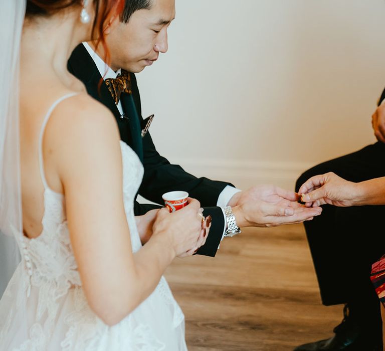 Bride & groom receive wedding rings from family members during Chinese Tea Ceremony