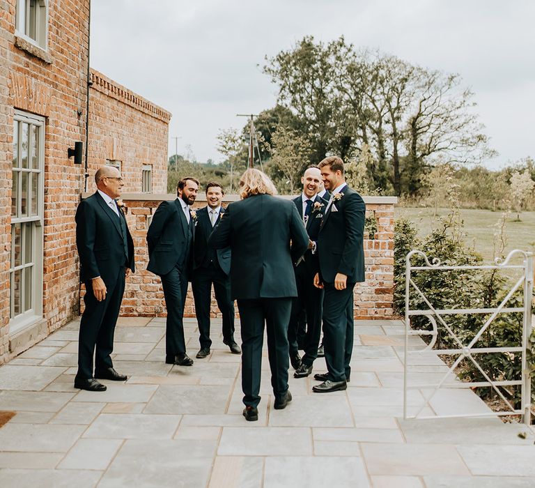 The groom and groomsmen laugh together as they spend the morning getting ready for the wedding at Duddon Mill Farm wedding venue 