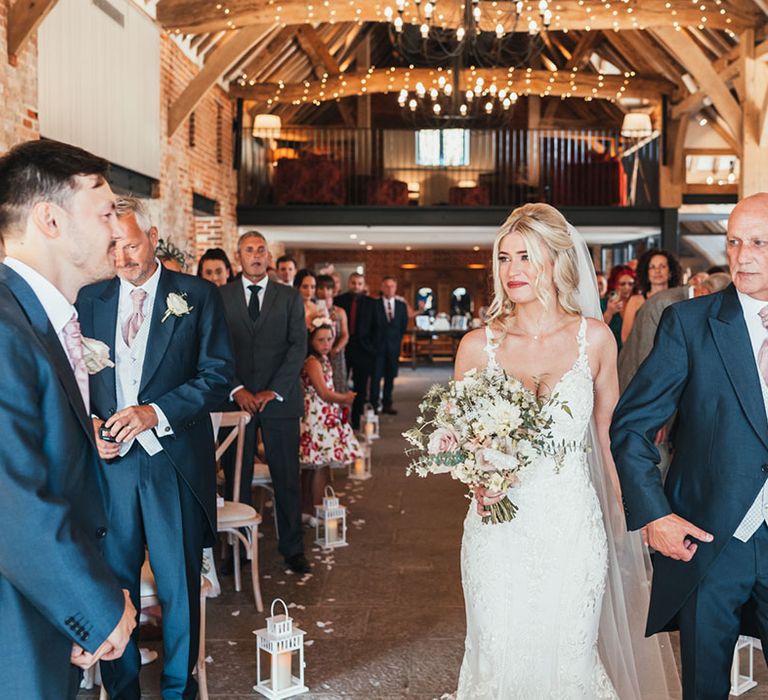 The father of the bride walks the bride down the aisle to meet the groom at Rackleys Chiltern Hills barn wedding venue 