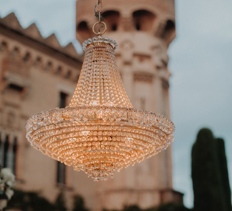 Large outdoor bejewelled wedding chandelier at castle wedding venue 