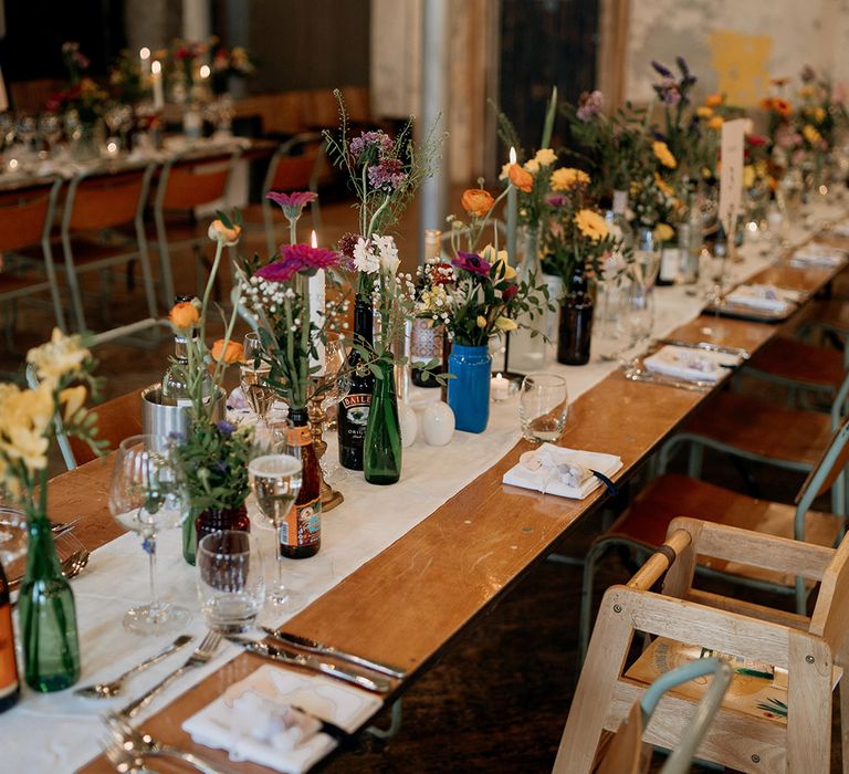 The tables are decorated with simple and colourful wildflowers for the wildflower wedding theme 