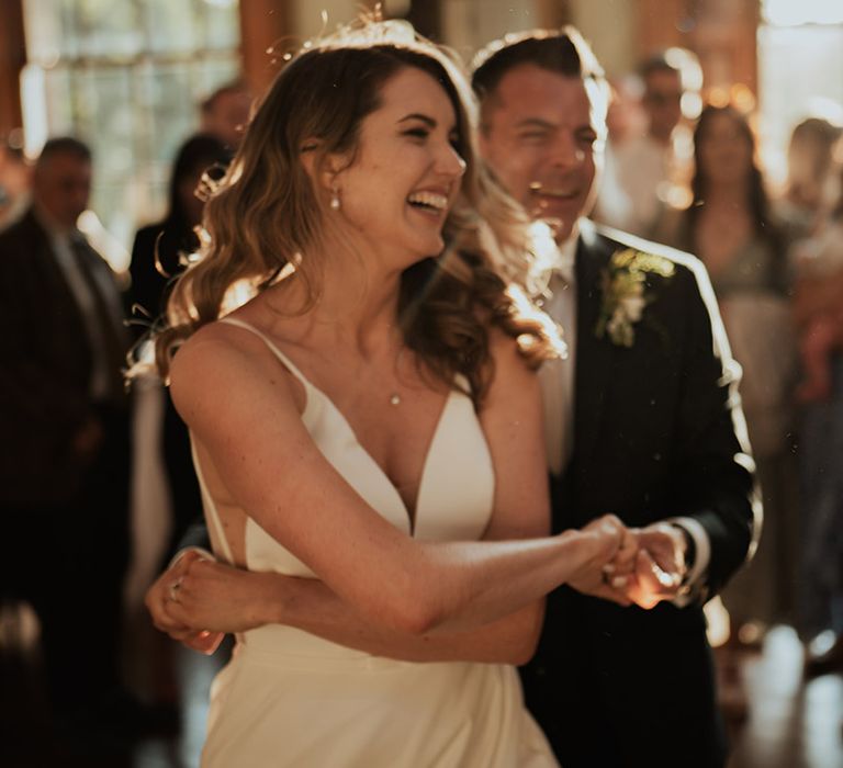 The bride and groom can't stop smiling as they have their first dance together 