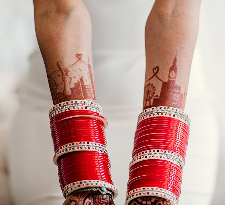 Bride wearing red and gold wedding bangles with London inspired henna design 