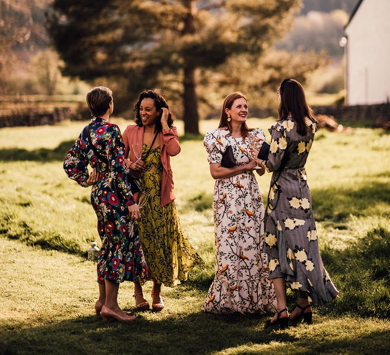 Wedding guests in different colour floral dresses 