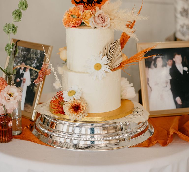 Retro style black and orange heart shaped wedding cake topper on white wedding cake 