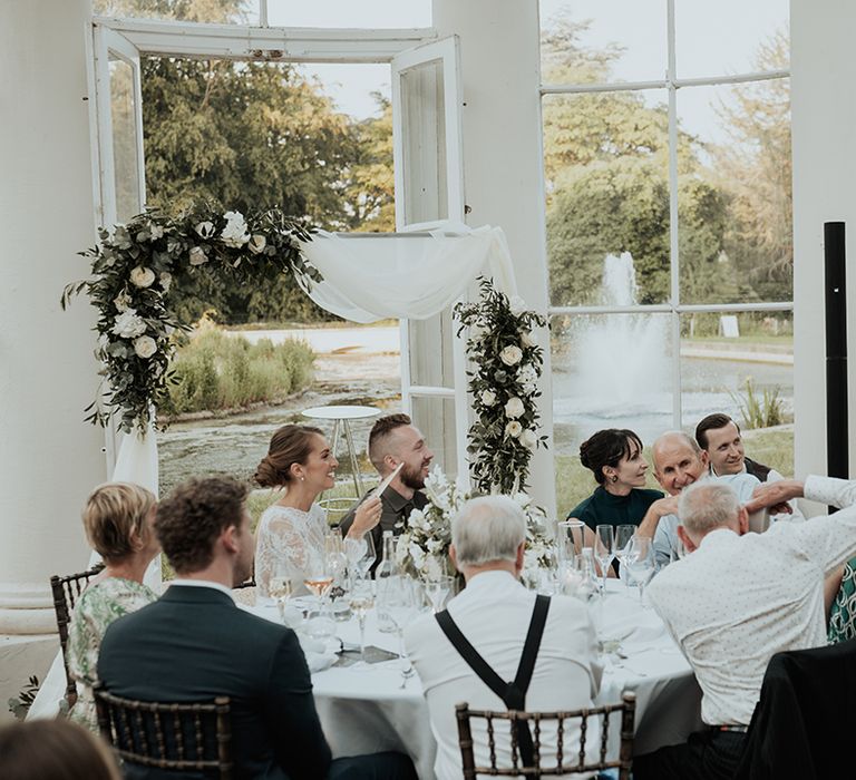 bridesmaid in sage green dress singing during the wedding reception at Gunnersbury Park 