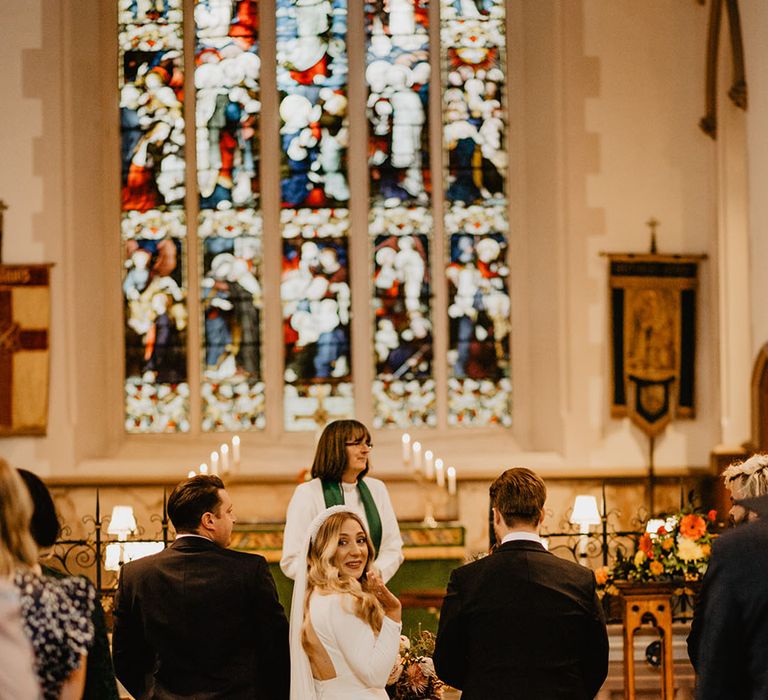 Bride in long sleeve wedding dress from Sassi Holford with back cutout design 